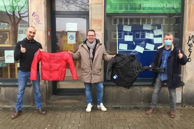Tobias Fechner von der Krisenhilfe (l.) nimmt die Winterkleidung von Jörg Laftsidis und Burkart Jentsch (m.) entgegen